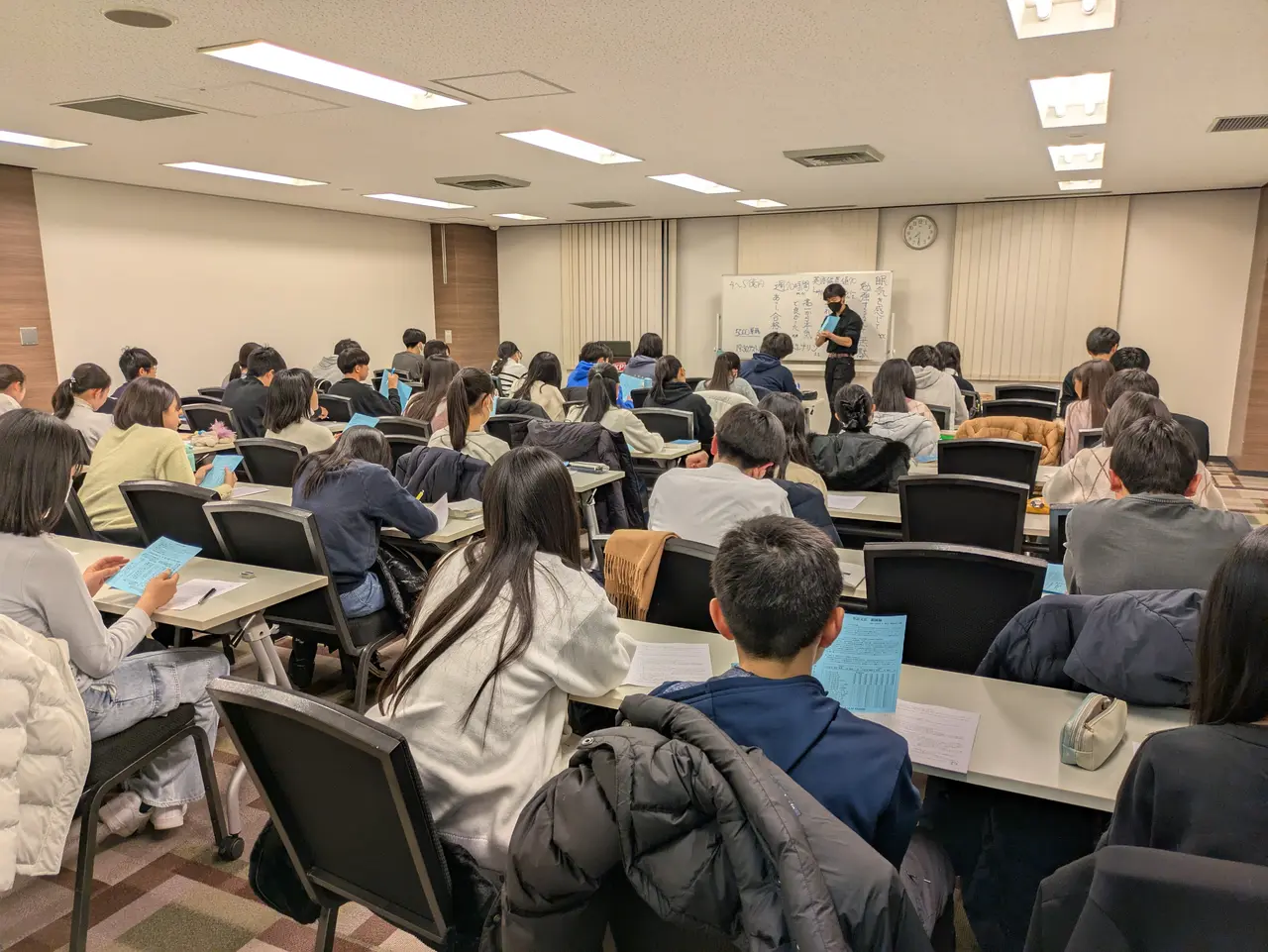 会議室で大勢の塾生が講師の話を聞いている特別講習の様子
